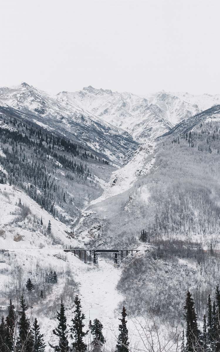 iphone wallpapers black bridge surrounded by mountain covered with snow under white sky iphone backgrounds